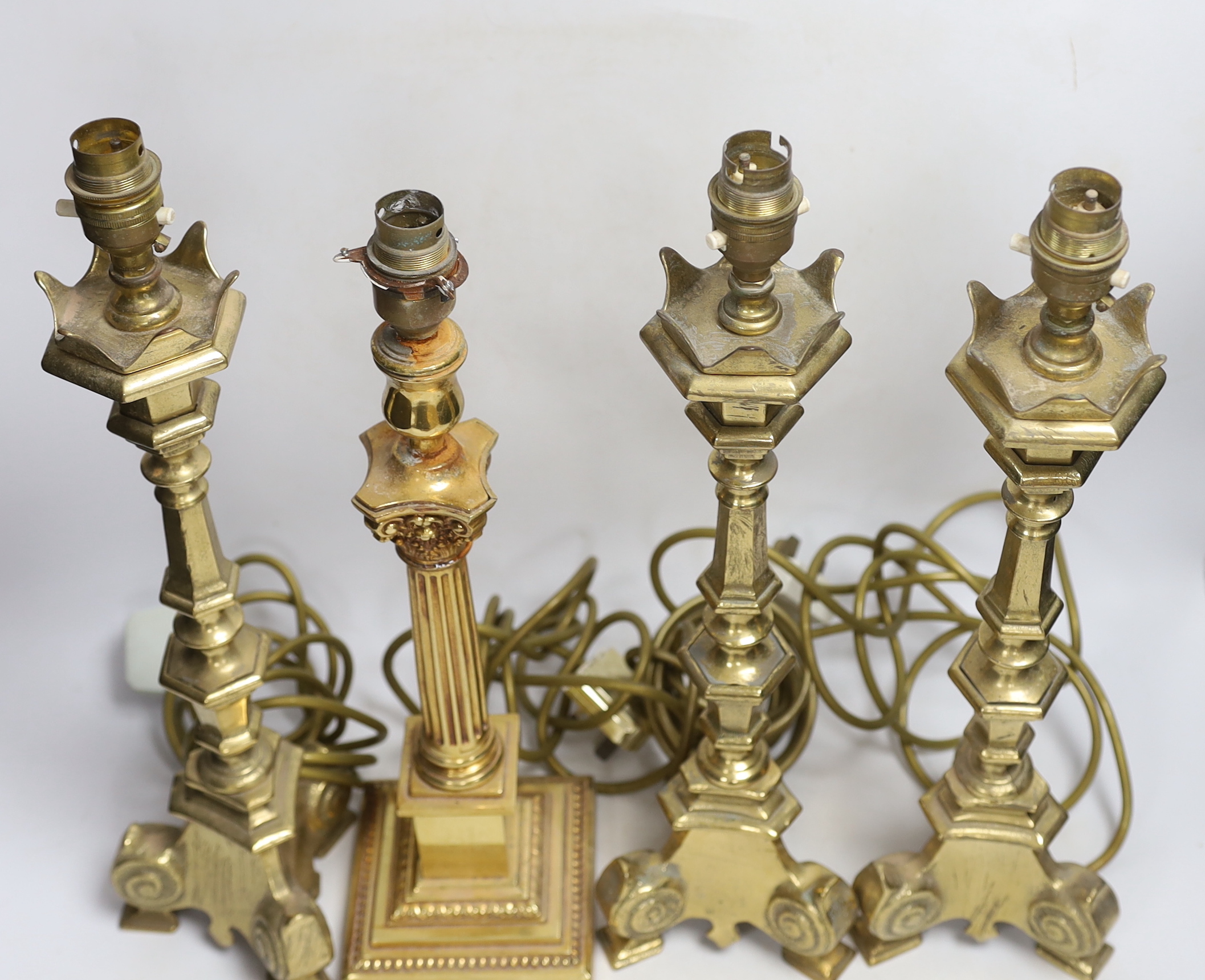 Four brass column lamps including a set of three, largest each 44cm high